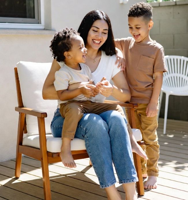 mother and two children playing safely on a clean backyard patio under sunlight